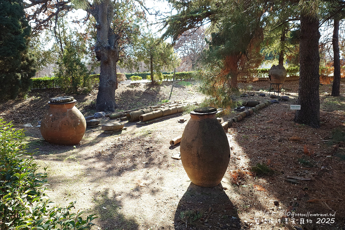 特洛伊遺址皮托斯花園全景，可見古代陶管與陶甕設施，展現公共建設與儲藏智慧