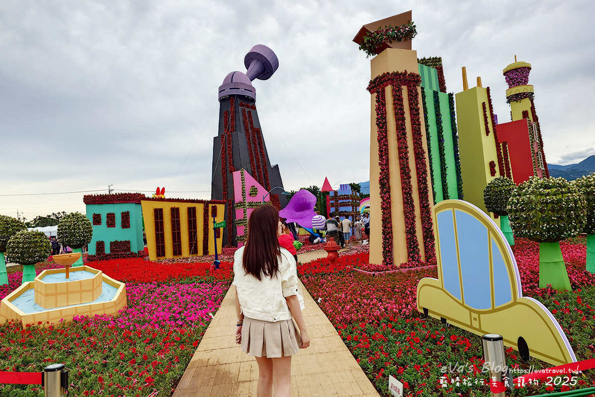 【台中景點】2025臺中國際花毯節|花城任務 × 飛天小女警(展期11/08–11/30,寵物友善)漸層花海打造繽紛色彩世界。台中親子旅遊 - 第27張圖 走進花城任務小鎮村前往魔人啾啾基地參觀的場景