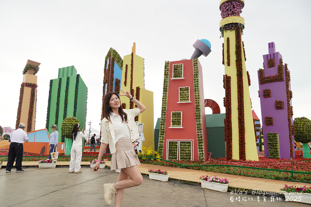 【台中景點】2025臺中國際花毯節|花城任務 × 飛天小女警(展期11/08–11/30,寵物友善)漸層花海打造繽紛色彩世界。台中親子旅遊 - 第50張圖 我在花城任務小鎮村前比YA拍照2