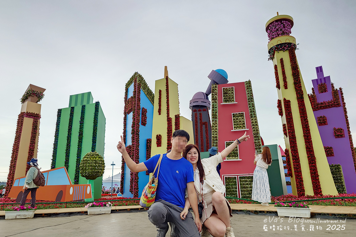【台中景點】2025臺中國際花毯節|花城任務 × 飛天小女警(展期11/08–11/30,寵物友善)漸層花海打造繽紛色彩世界。台中親子旅遊 - 第58張圖 我和老公在花城任務小鎮村前拍照合影1